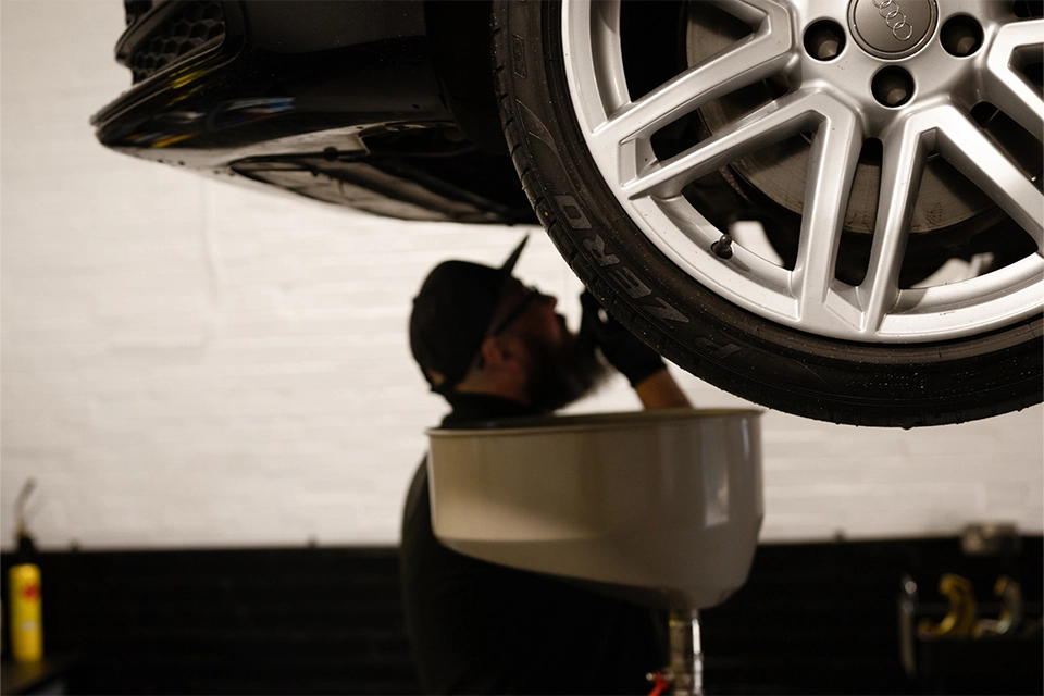 Mechanic working under vehicle raised on car lift